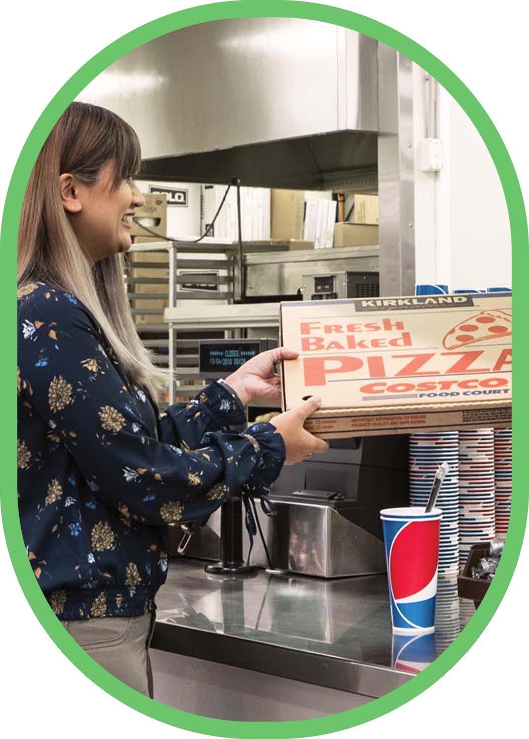 Fresh-baked Kirkland pizza being passed over the Costco food court counter